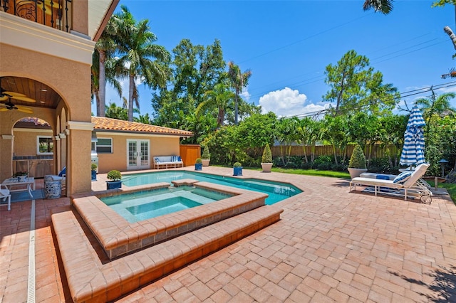 view of swimming pool with a fenced in pool, a fenced backyard, an in ground hot tub, french doors, and a patio area