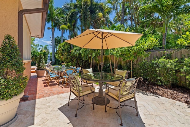 view of patio featuring outdoor dining space and fence