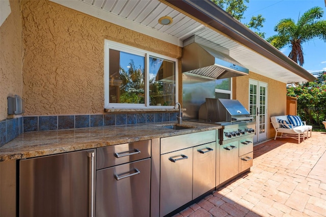 view of patio / terrace with grilling area, an outdoor kitchen, and a sink