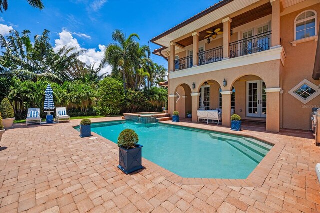 view of pool with ceiling fan, a patio area, and a pool with connected hot tub