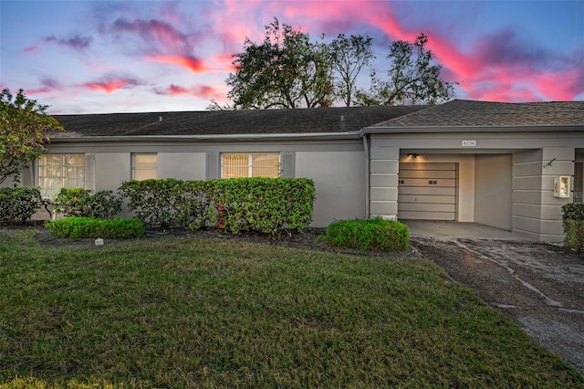 ranch-style home with a lawn and a garage