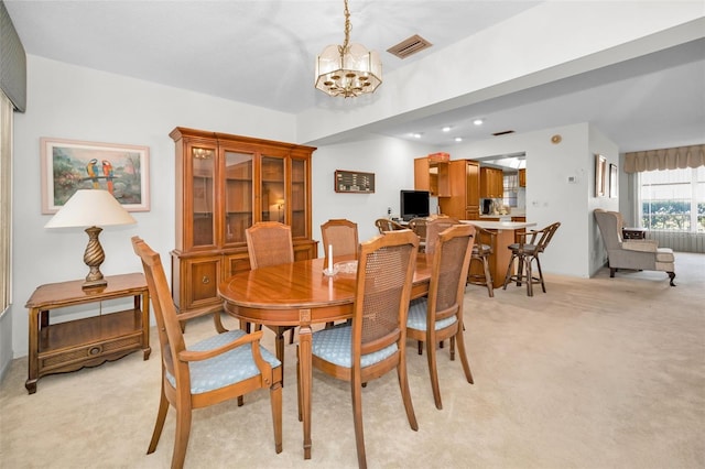 dining area with light carpet and an inviting chandelier