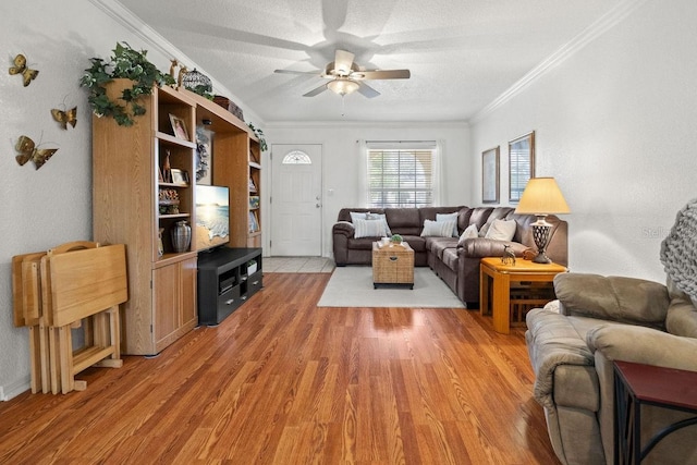 living room with light wood-type flooring, ceiling fan, crown molding, and a textured ceiling