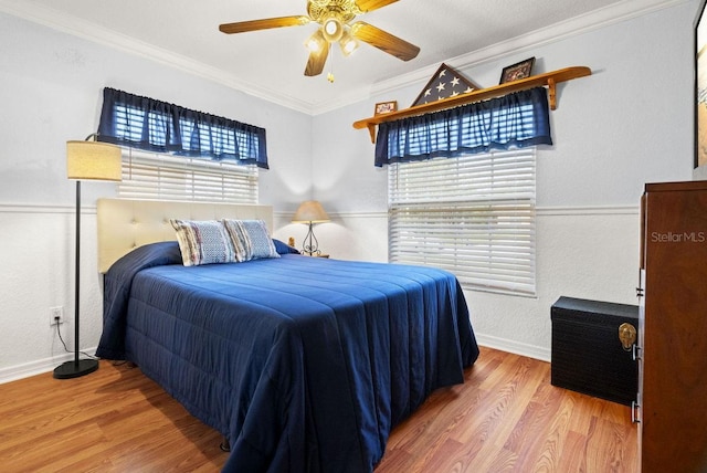 bedroom with ceiling fan, crown molding, and hardwood / wood-style flooring