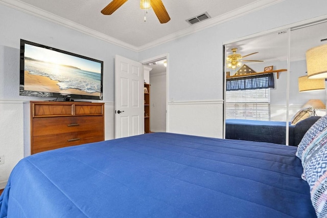 bedroom with ceiling fan, a textured ceiling, a closet, and ornamental molding