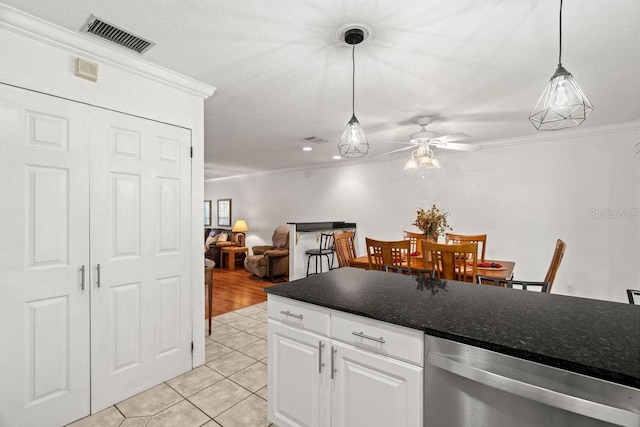 kitchen featuring ceiling fan, light tile patterned flooring, ornamental molding, pendant lighting, and white cabinets