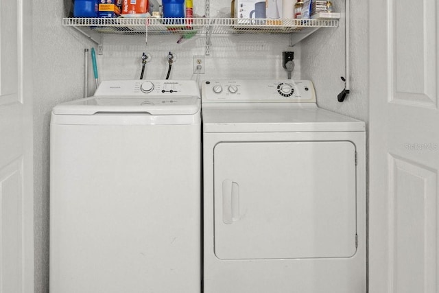 clothes washing area with washing machine and dryer