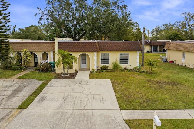 view of front of house featuring a front lawn and cooling unit