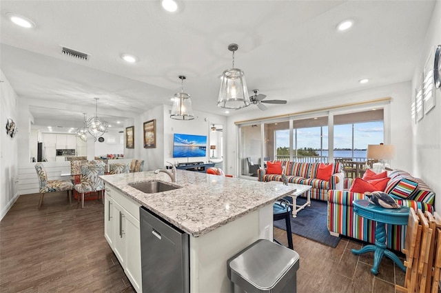 kitchen featuring pendant lighting, sink, white cabinetry, a kitchen island with sink, and light stone counters