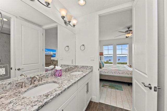 bathroom with ceiling fan, a water view, and vanity