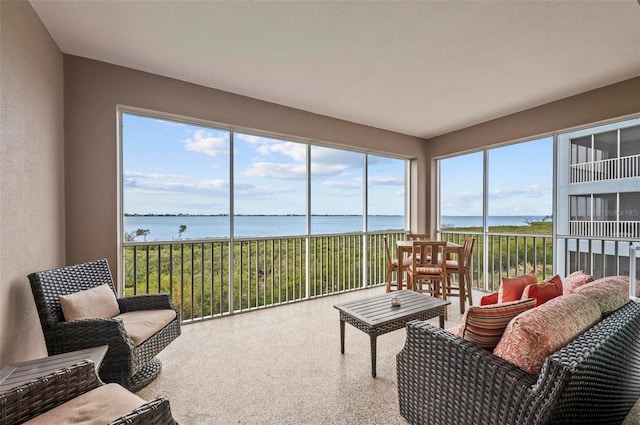 sunroom featuring a water view