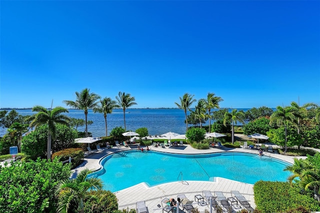 view of pool featuring a water view and a patio