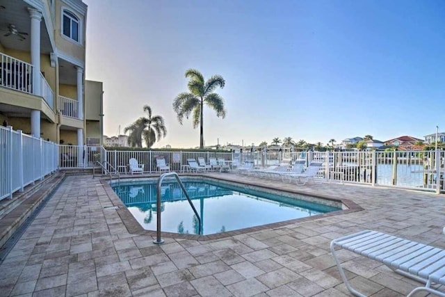 view of pool featuring a patio area and a water view