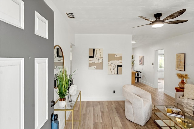 living room with ceiling fan and light hardwood / wood-style floors