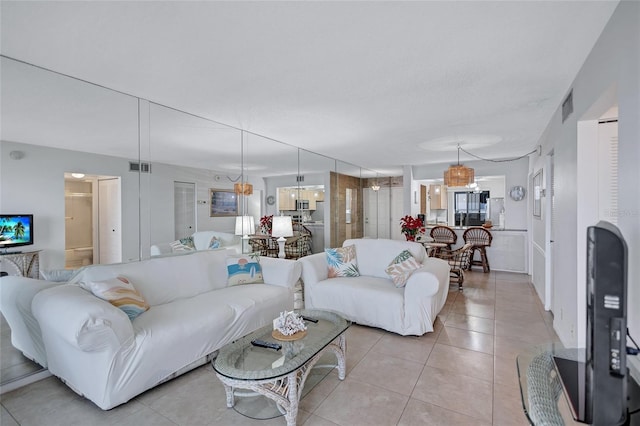 living room with light tile patterned flooring, a chandelier, and a textured ceiling