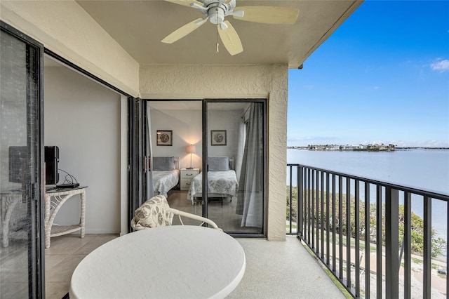 balcony with ceiling fan and a water view