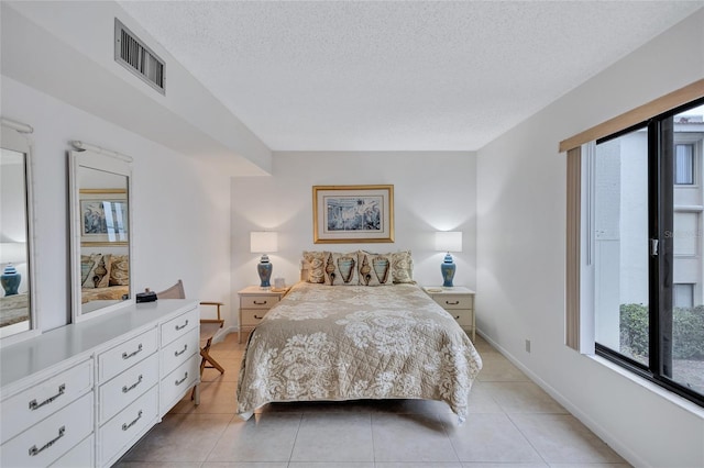 bedroom with a textured ceiling and light tile patterned flooring