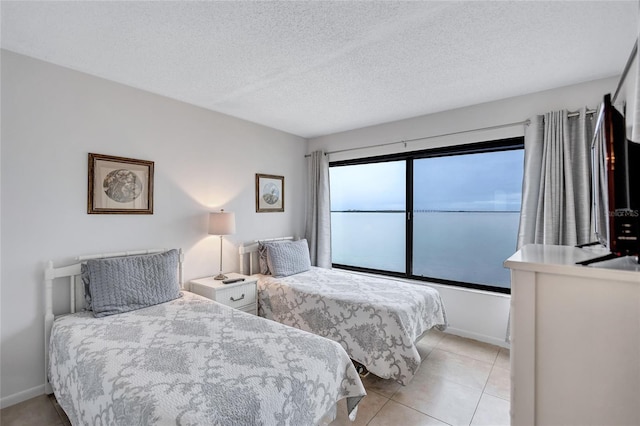 tiled bedroom with a textured ceiling