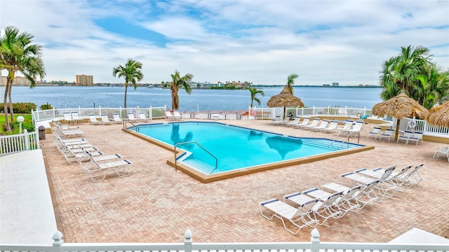 view of swimming pool featuring a patio area and a water view