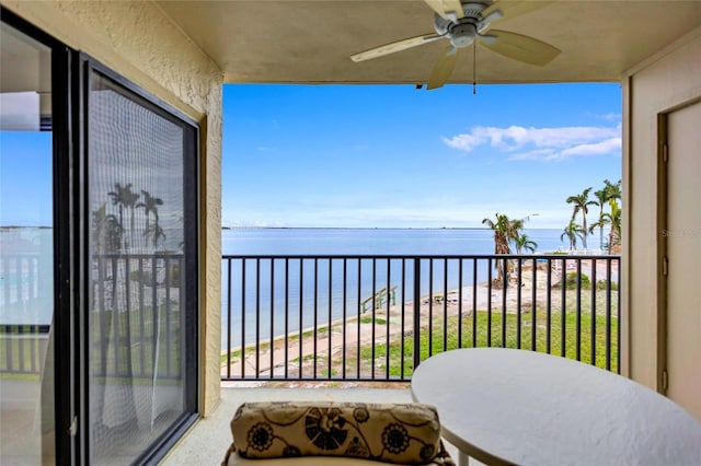 balcony with ceiling fan and a water view