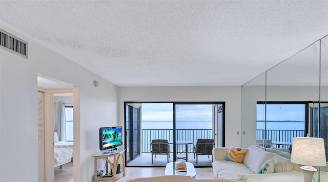 living room with light tile patterned flooring, plenty of natural light, and a textured ceiling