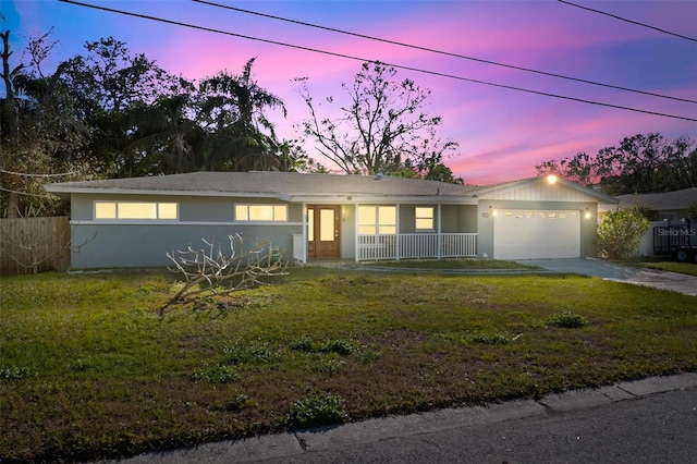 single story home featuring a garage and a yard