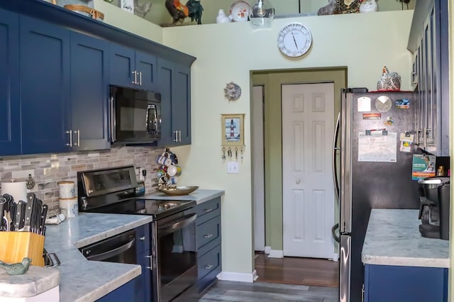 kitchen with dark hardwood / wood-style floors, blue cabinetry, appliances with stainless steel finishes, and backsplash