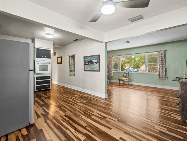 interior space featuring hardwood / wood-style flooring, stainless steel refrigerator, ceiling fan, and white oven