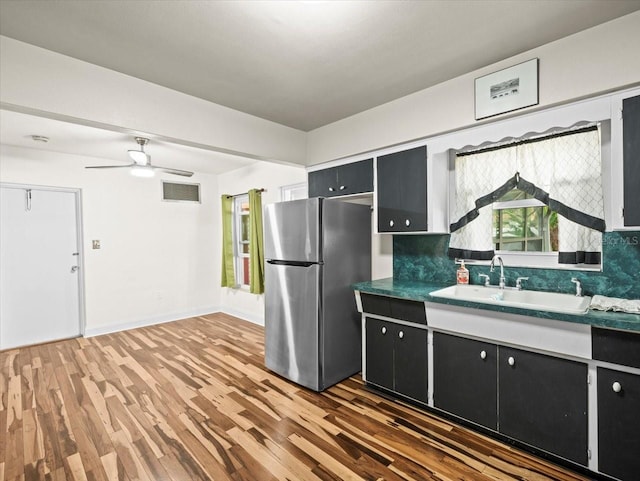 kitchen featuring sink, stainless steel refrigerator, dark hardwood / wood-style flooring, ceiling fan, and backsplash