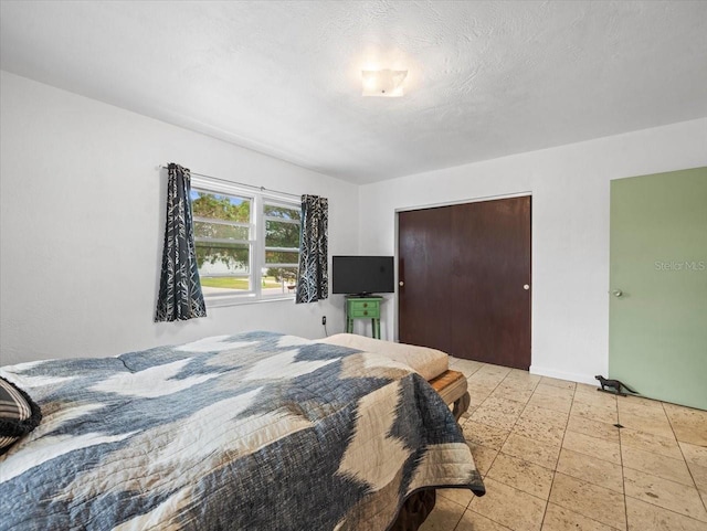 bedroom with a textured ceiling and a closet