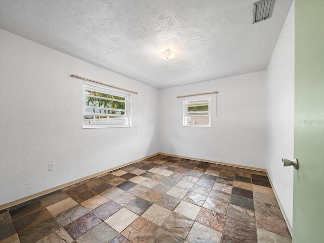 unfurnished room featuring a textured ceiling