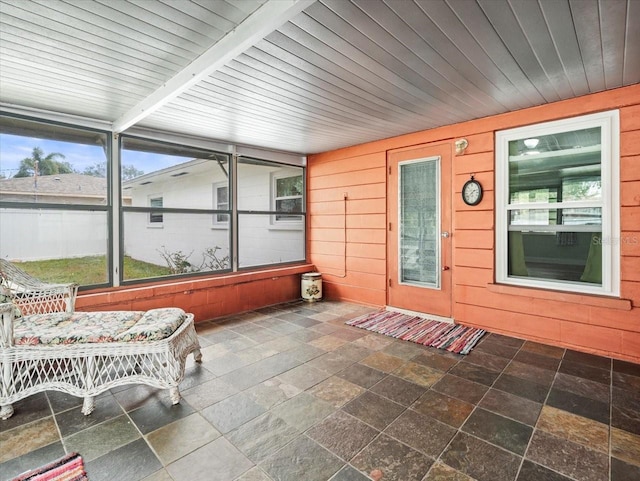 unfurnished sunroom with plenty of natural light and wooden ceiling