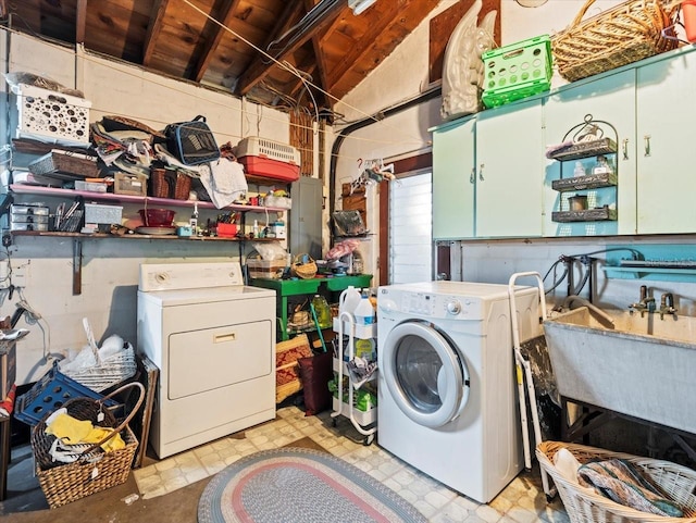 washroom featuring washing machine and dryer, a sink, and cabinet space