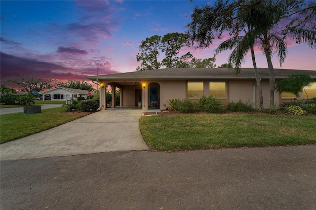 view of front facade featuring a lawn and a carport