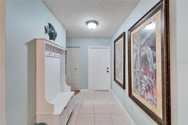 mudroom with light tile patterned floors and a textured ceiling