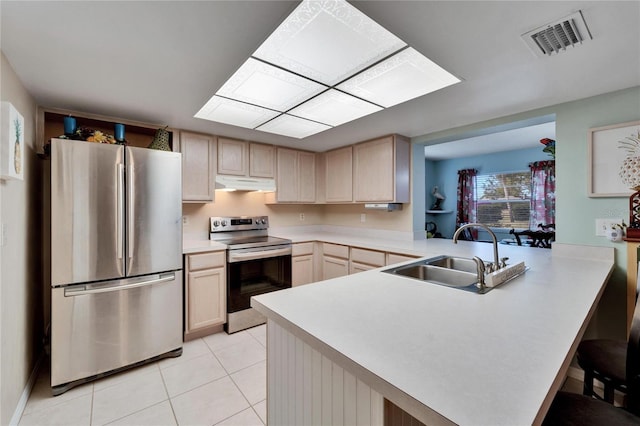 kitchen featuring kitchen peninsula, appliances with stainless steel finishes, sink, and light brown cabinets