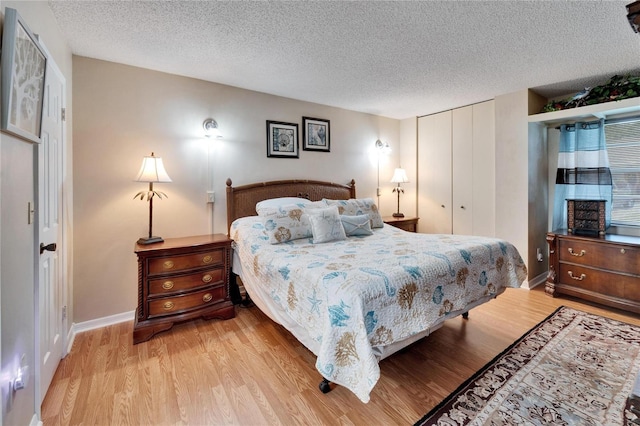 bedroom featuring a textured ceiling, a closet, and light hardwood / wood-style flooring