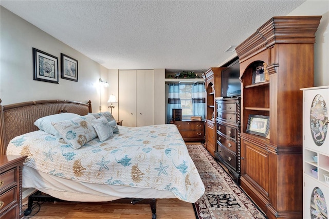 bedroom with a textured ceiling and a closet