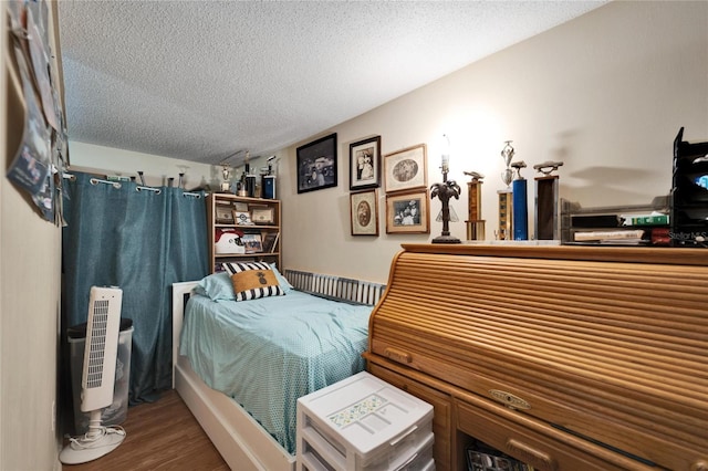 bedroom with wood-type flooring and a textured ceiling