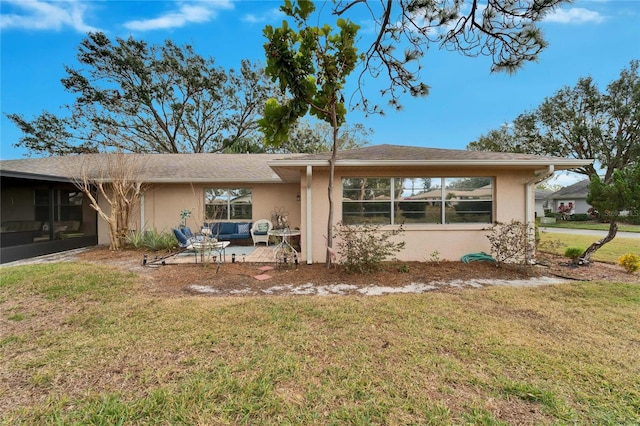 ranch-style home with a front yard and a patio area