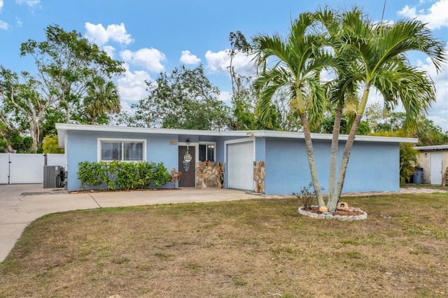 ranch-style home featuring central AC, a front lawn, and a garage