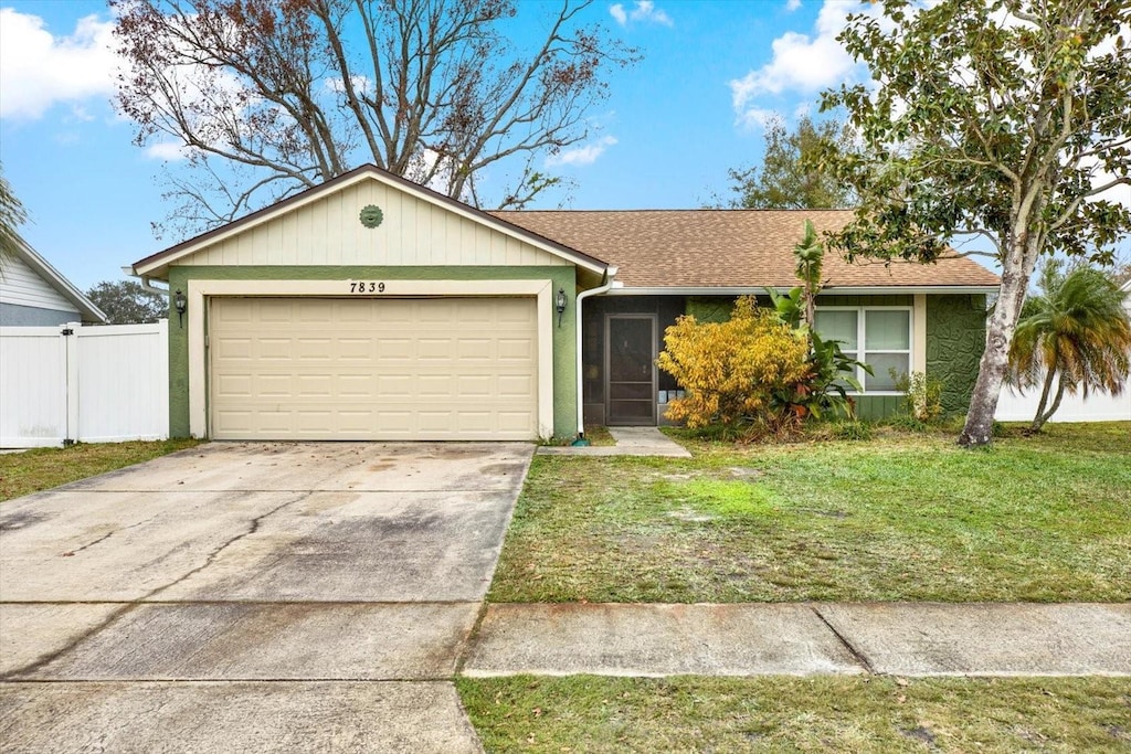 ranch-style house with a garage and a front yard