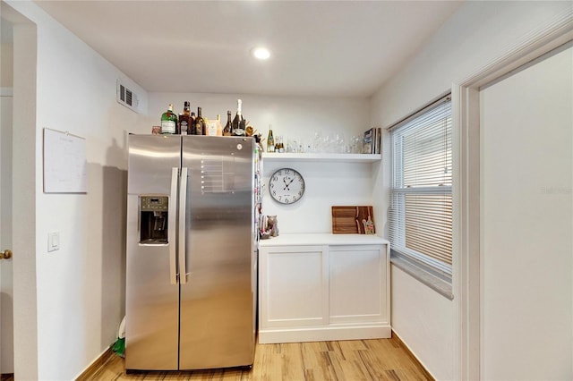 kitchen with stainless steel fridge and light hardwood / wood-style flooring