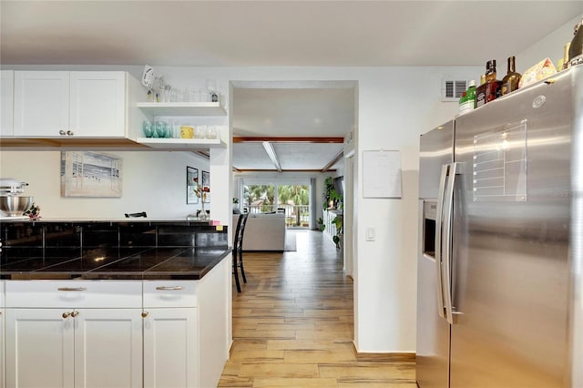 kitchen with white cabinetry, stainless steel refrigerator with ice dispenser, and light wood-type flooring