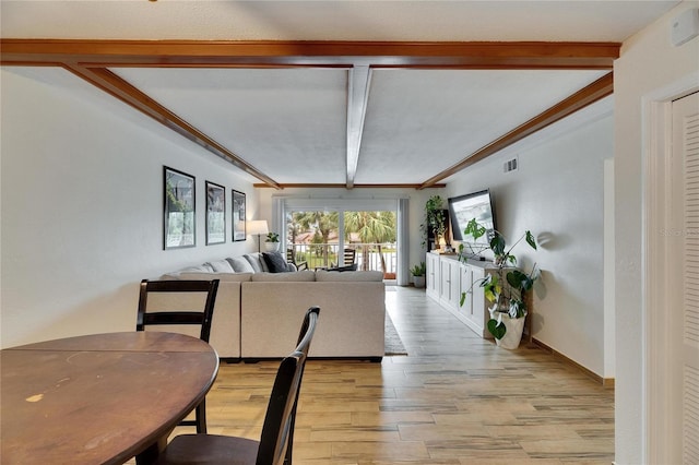 living room featuring crown molding, beam ceiling, and light wood-type flooring