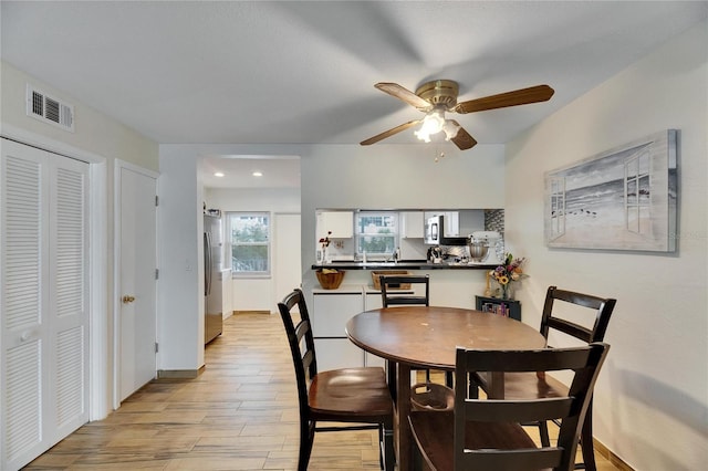 dining room with ceiling fan and light hardwood / wood-style floors