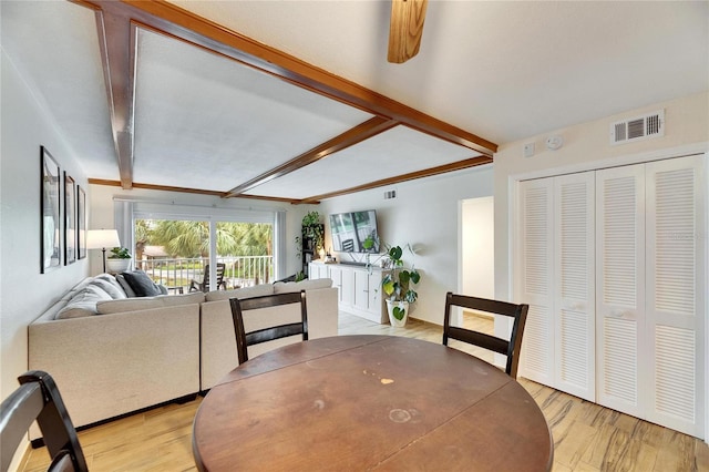 dining room with light hardwood / wood-style flooring and beamed ceiling