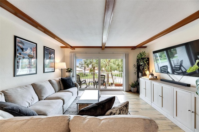 living room with beam ceiling, a textured ceiling, and light hardwood / wood-style floors