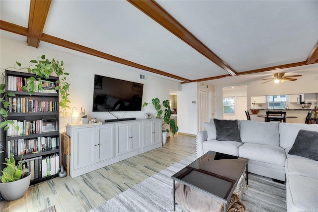 living room with ceiling fan, beam ceiling, and light hardwood / wood-style floors