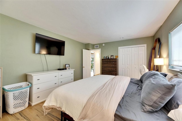 bedroom with light hardwood / wood-style floors and a closet